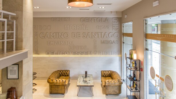 A modern lobby with a large wall displaying text, two leather sofas, a coffee table, and a glass display case.