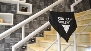 A staircase with a black banner reading "CONTRA AC VIOLENCE" and white railings.