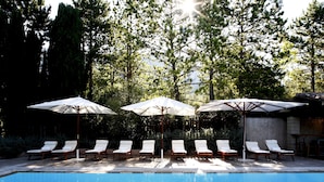 A swimming pool with lounge chairs and umbrellas.