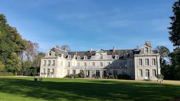 Stately building with a classical design, surrounded by a well-manicured lawn and trees.