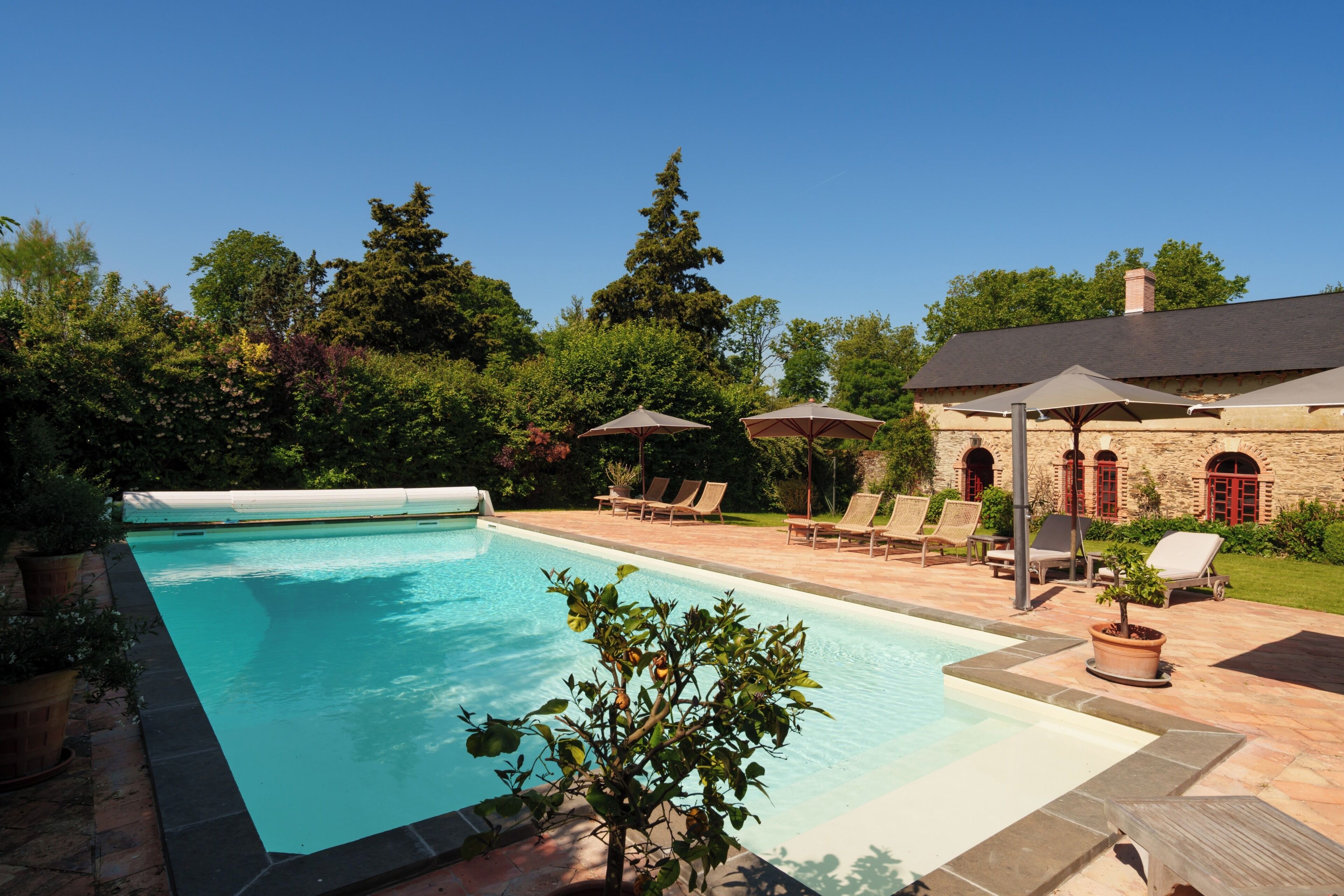 Una piscina al aire libre, sillones reclinables de piscina