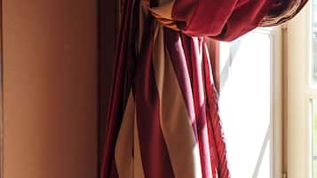 A curtain tied in a knot, a window, and a wall.