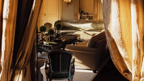 A room with a sofa, armchair, and a table with decorative items.