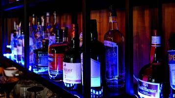 Un bar dont les étagères sont remplies de différentes bouteilles d’alcool.