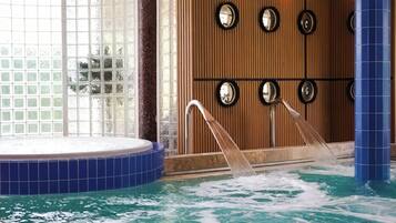 Une piscine intérieure avec un mur en bois et des miroirs ronds.