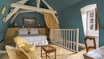 Een slaapkamer met een bed, een stoel, een klein tafeltje, een wieg en een raam.