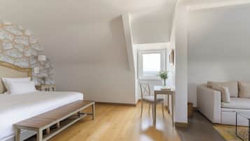 A bedroom with a bed, bench, chair, and a small table with a vase.