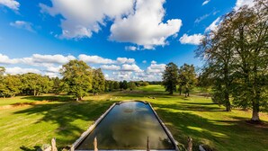 A swimming pool with a view of a golf course and trees. - Garrigae Manoir de Beauvoir (Mignaloux-Beauvoir)