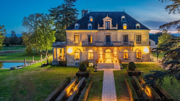A large, well-lit mansion with a formal garden, a pond, and a symmetrical pathway leading to the entrance. - Garrigae Manoir de Beauvoir (Mignaloux-Beauvoir)