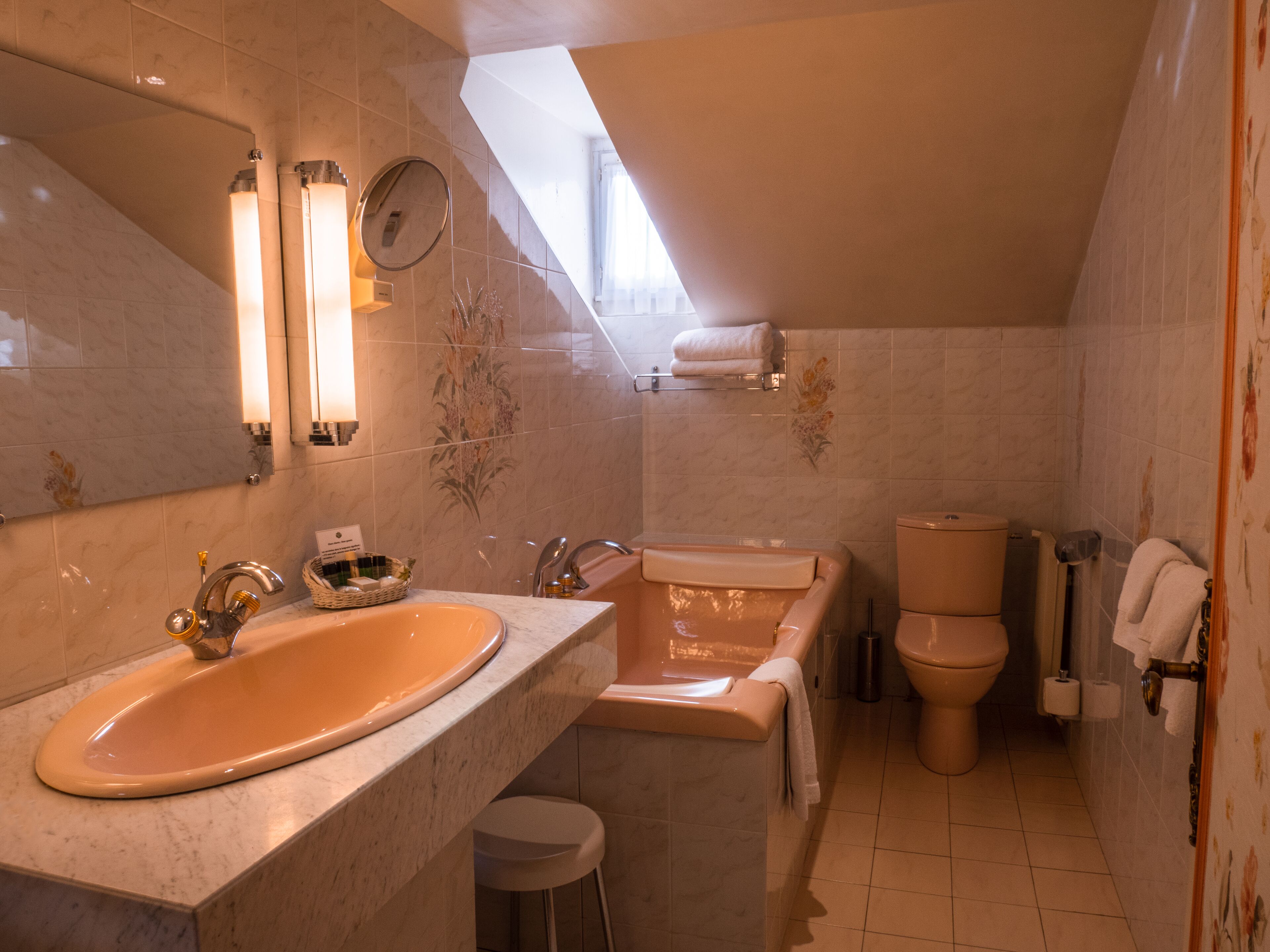 Une salle de bain avec un grand lavabo ovale, une baignoire, des toilettes et un miroir.