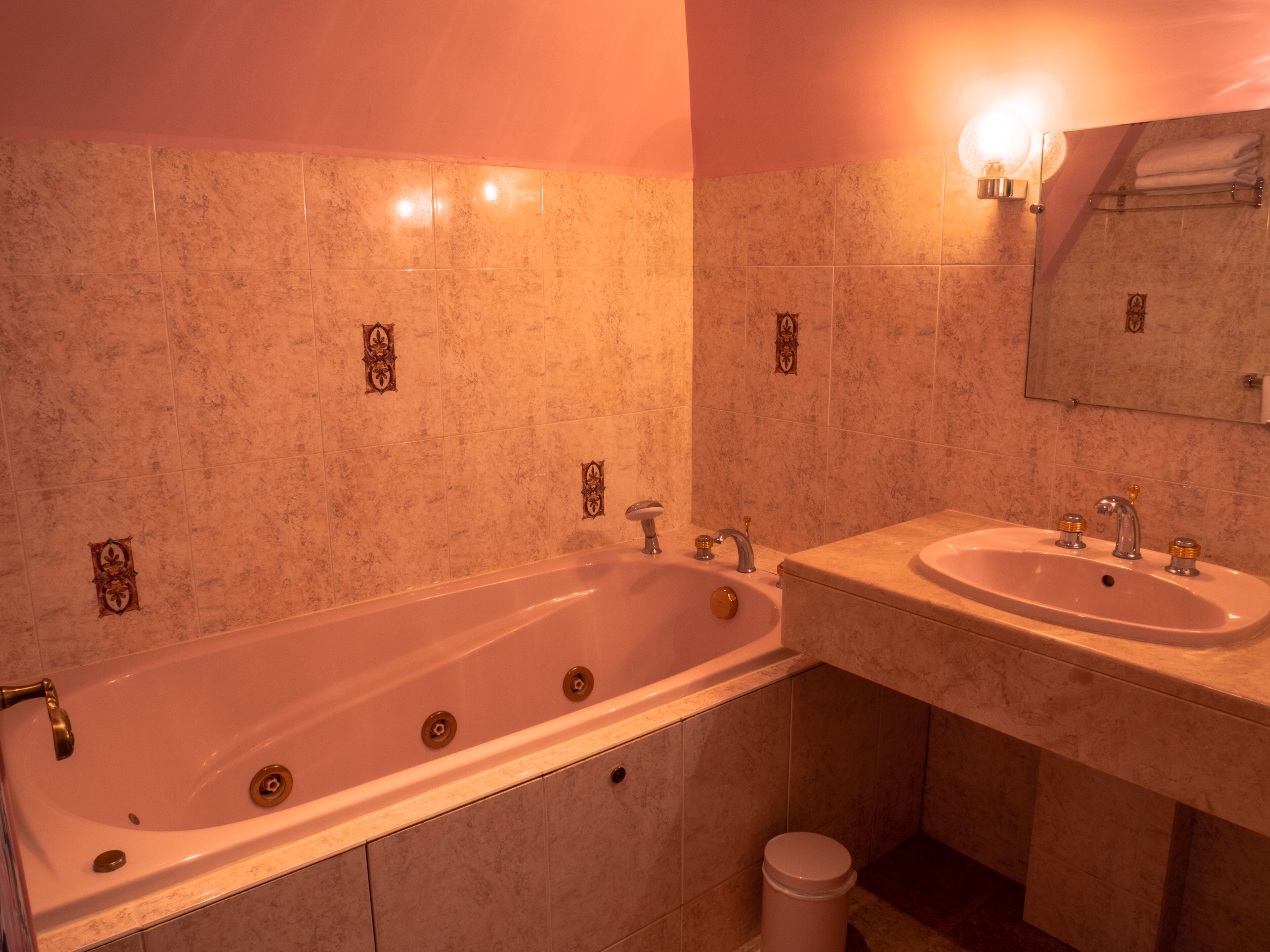 A bathroom with a large bathtub, two sinks, and a mirror.