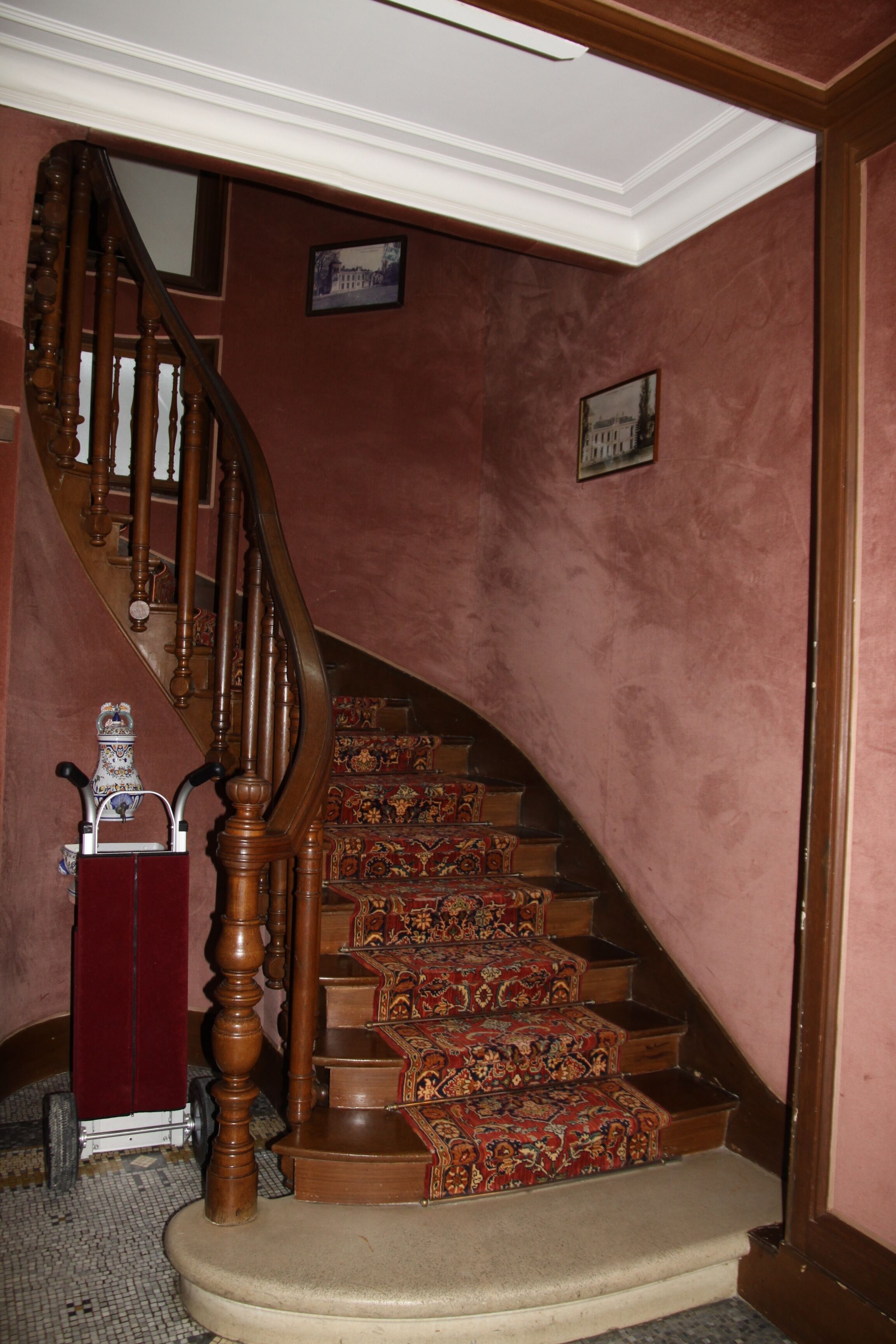A staircase with ornate wooden balusters and a carpeted landing.