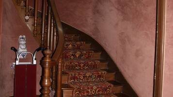 A staircase with ornate wooden balusters and a carpeted landing.