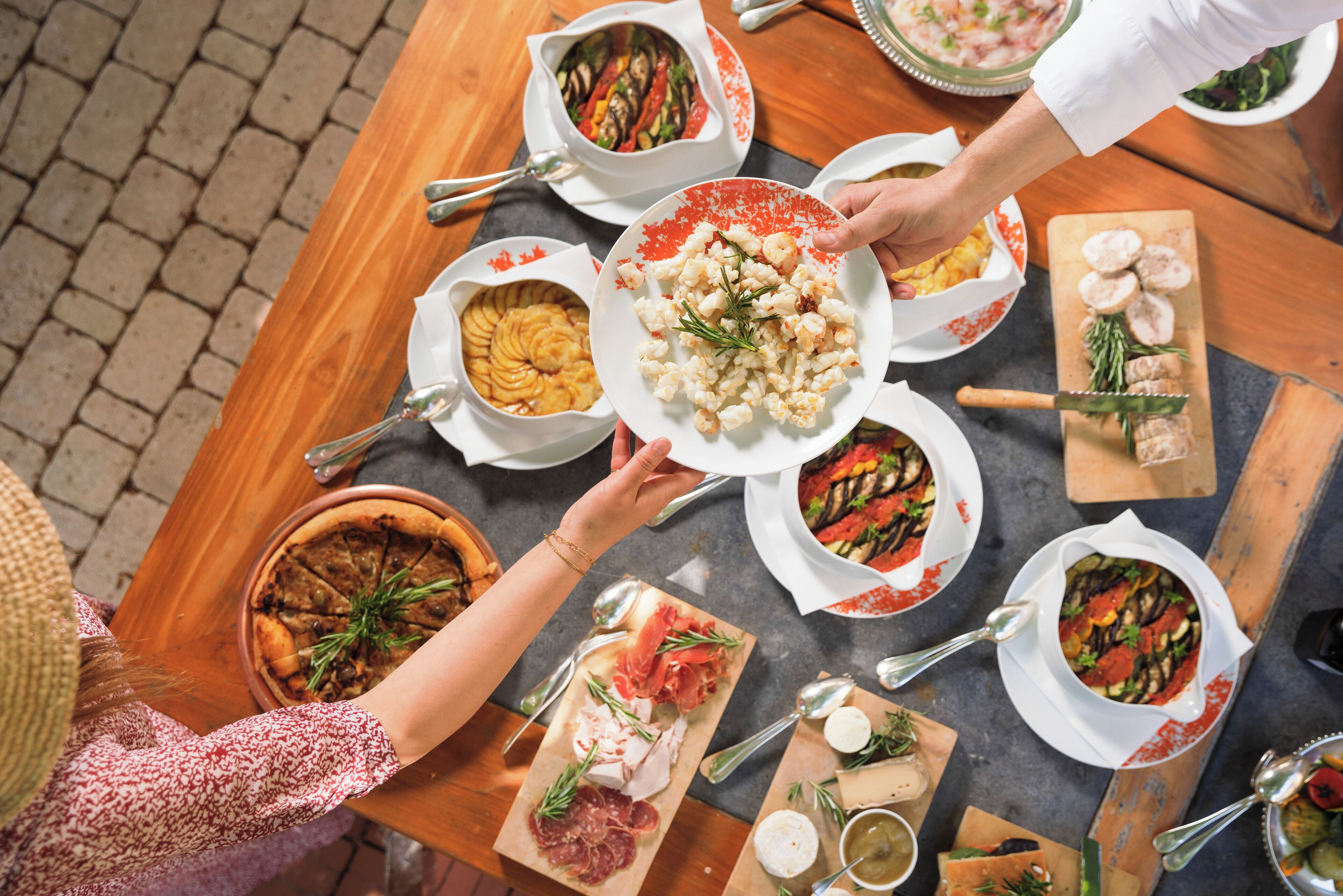 Una mesa con diferentes platos, incluyendo un pastel, una fuente de comida y varios cuencos de sopa.