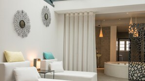 Una sala de estar moderna con un sofá blanco, una mesita y un elemento decorativo en la pared.