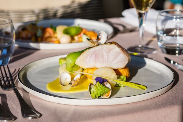 A plate of food with a fish fillet, vegetables, and a sauce. - Atlantic Hotel & Spa (Les Sables-d'Olonne)