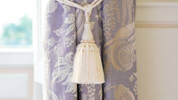 A curtain with a floral pattern and a tassel hanging from the top.