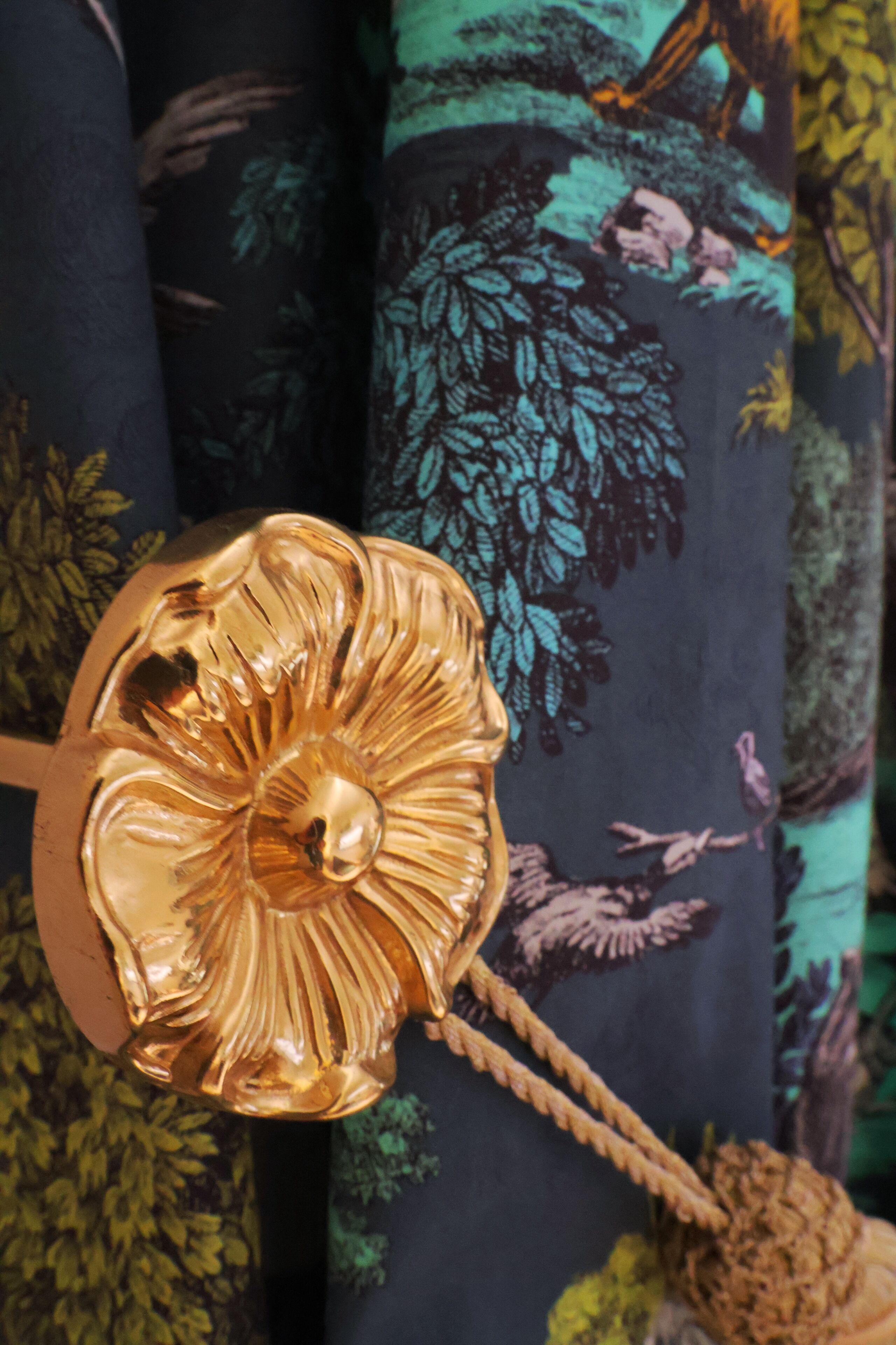 A decorative golden object with a floral design, possibly a part of a piece of furniture or decor.