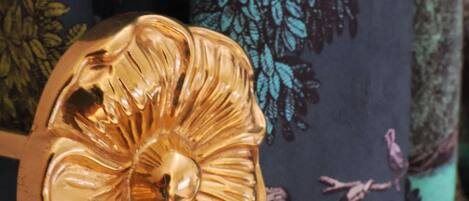 A decorative golden object with a floral design, possibly a part of a piece of furniture or decor.