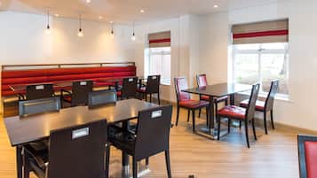 Enjoy meals in a spacious dining area with a long bench seating area and individual tables.