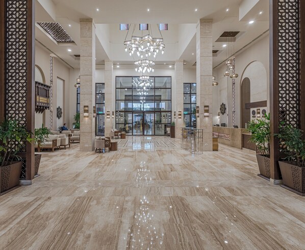 Experience the grandeur of our lobby, featuring a stunning chandelier, comfortable seating areas, and a polished floor.