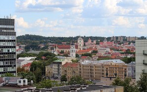 A cityscape with a mix of modern and historic buildings, including a prominent church with a bell tower. - Holiday Inn Vilnius by IHG (Vilnius)