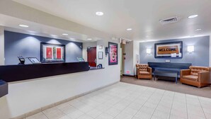 A reception area with a counter, a welcome sign, and seating.