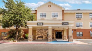 A hotel entrance with a lobby sign, numbered 4802, and a tree in front.