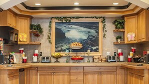 Eine Küche mit Holzausstattung, einer Mittelinsel und einem großen, gerahmten Bild an der Wand.