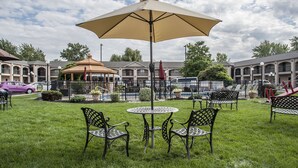 Ein Innenhof mit Sitzgelegenheiten im Freien, einem Kiosk und einem Pool.