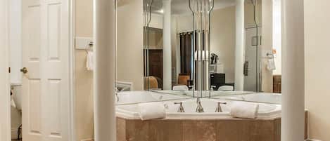 A bathroom with a large mirror, a bathtub, and a shower.