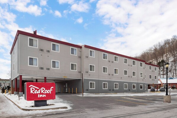 Ein Red Roof Inn Gebäude mit flacher Fassade, zahlreichen Fenstern und einem Parkplatz.