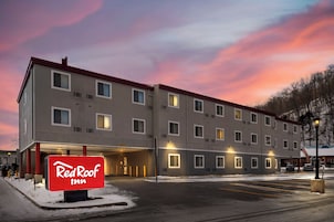 Edificio de Red Roof Inn con fachada plana, múltiples ventanas y estacionamiento.