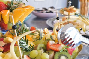 A fruit platter with various fruits and a fork. - AKZENT Hotel Franziskaner (Dettelbach)