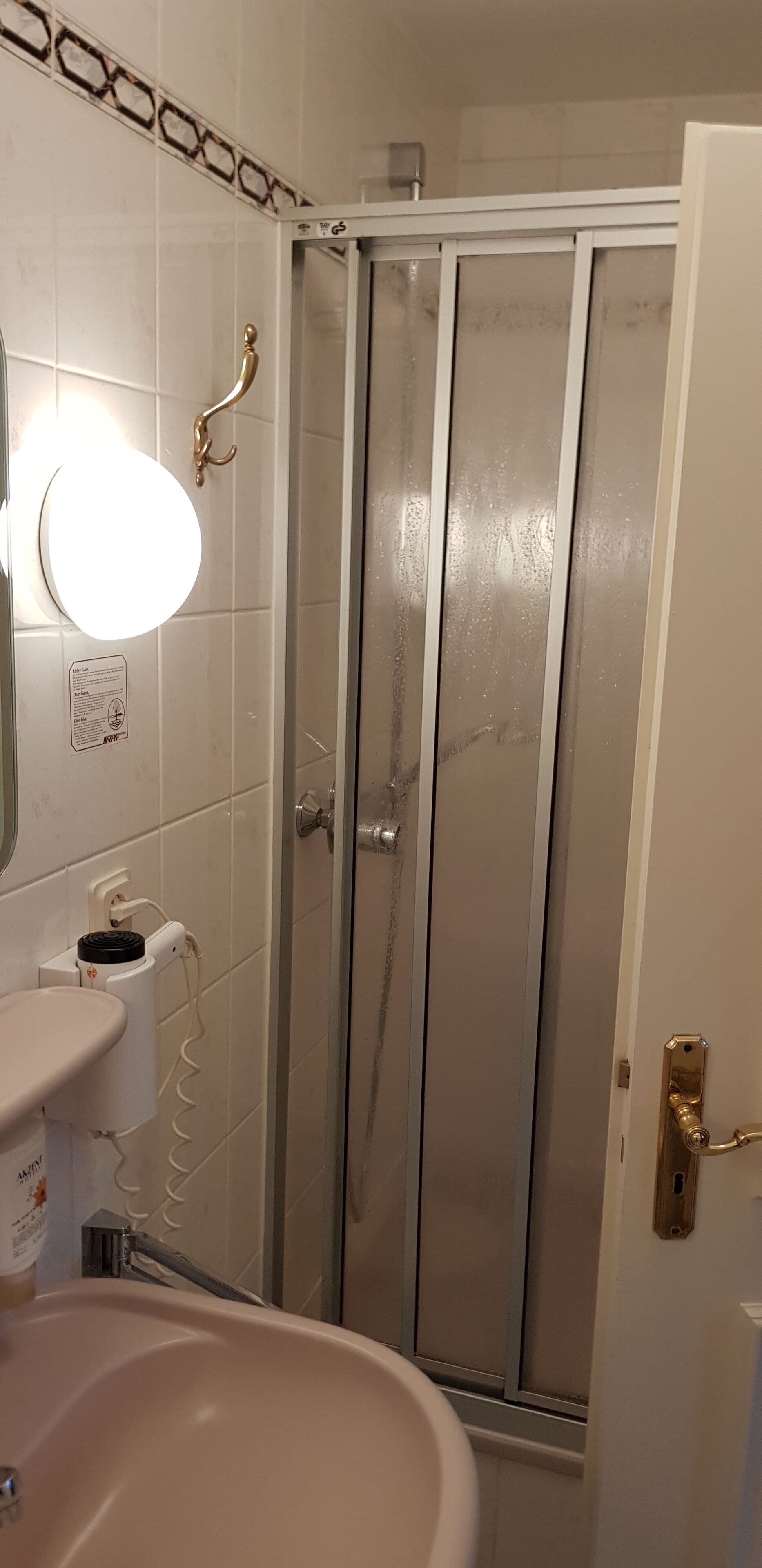 A bathroom with a sink, mirror, and shower door.