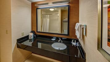 Un baño moderno con un lavabo negro, un espejo y una cortina de ducha.
