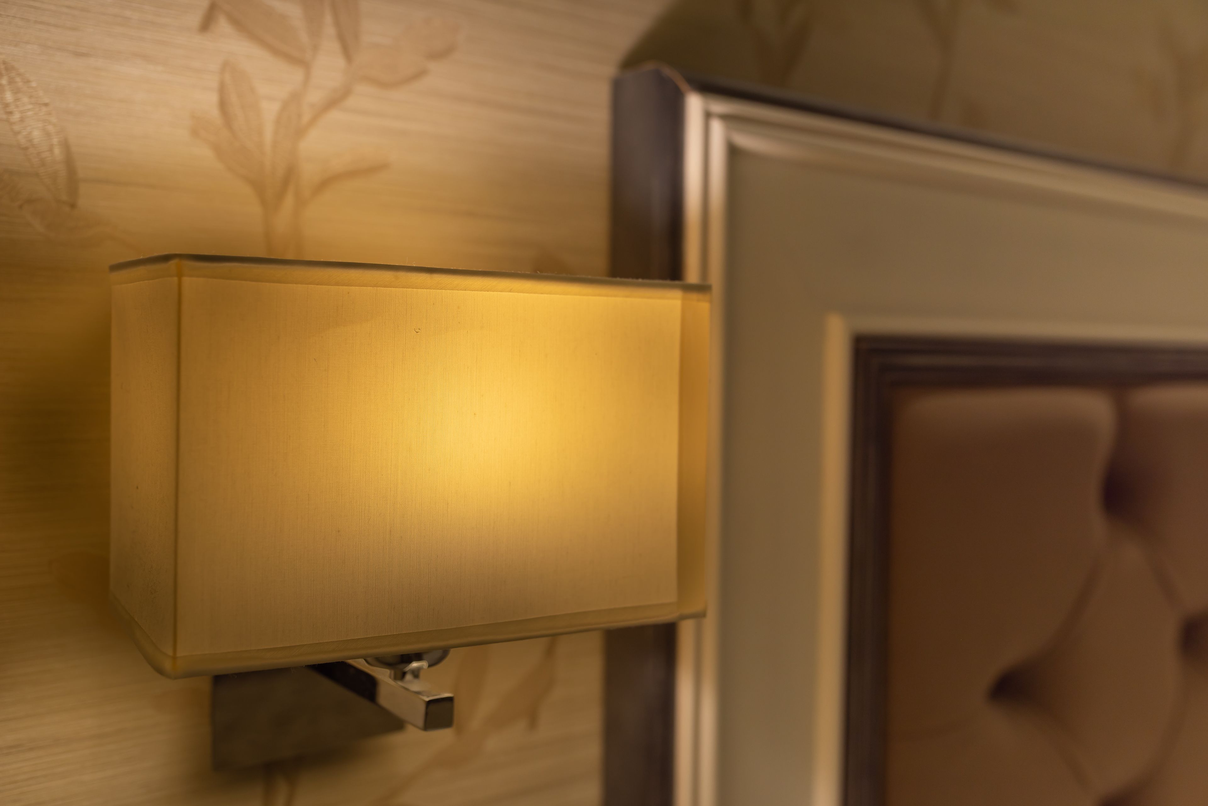 A wall-mounted light fixture with a rectangular shape and a metallic base.