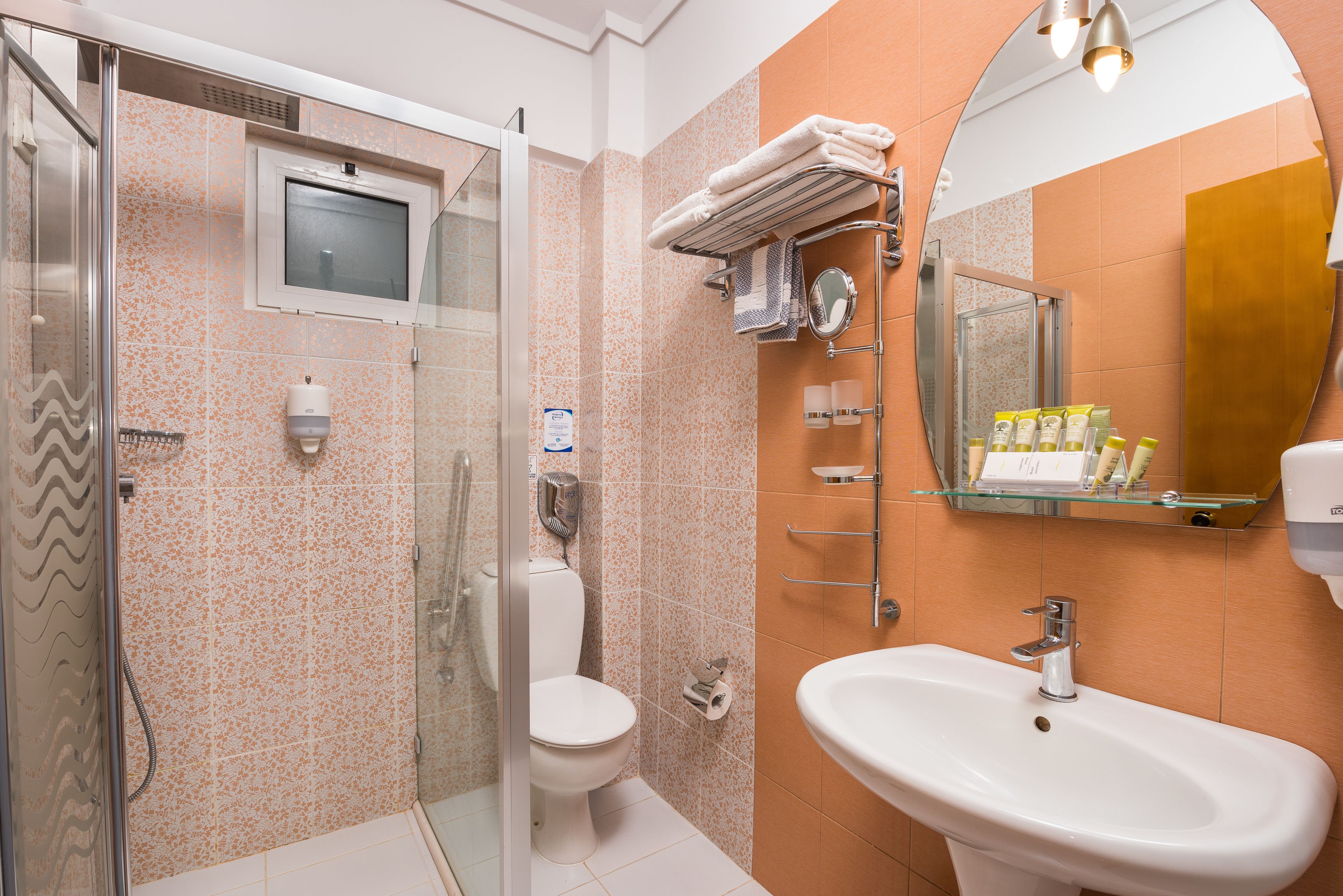 Un baño con ducha, inodoro, lavamanos y espejo.