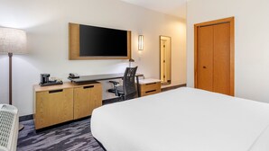A hotel room with a bed, desk, chair, and a TV mounted on the wall. - Fairfield Inn Suites by Marriott Cherokee (Cherokee)