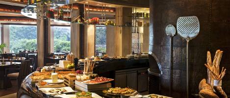 A buffet with various dishes and a glass display case with bottles.