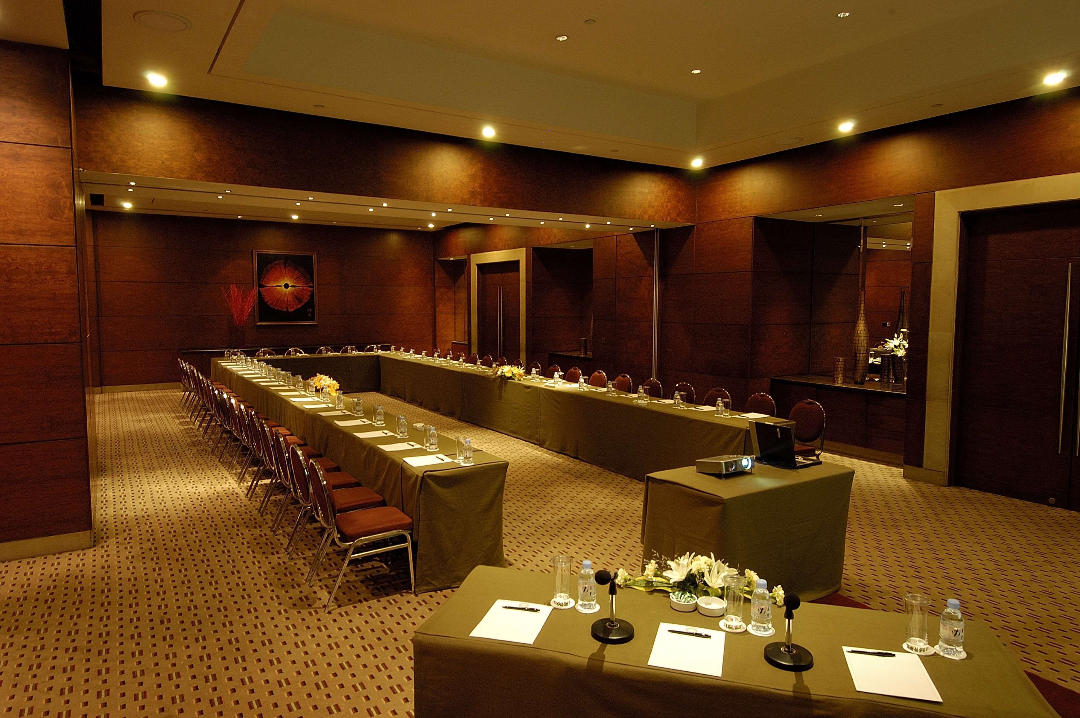 A conference room with long tables, chairs, and a podium.