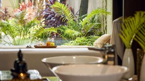 Un baño con un ventanal grande, un lavabo y un espejo.