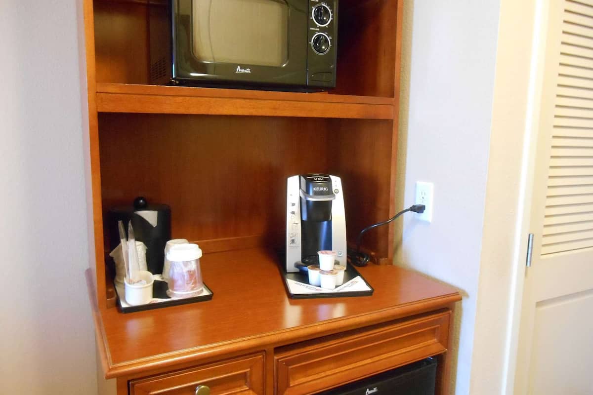 A kitchenette with a microwave, coffee maker, and a small refrigerator.