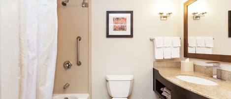 A modern bathroom with a bathtub, toilet, and sink.
