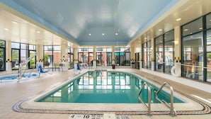 An indoor swimming pool with clear water, tiled floor, and a 'No Diving' sign.