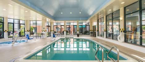 An indoor swimming pool with clear water, tiled floor, and a 'No Diving' sign.
