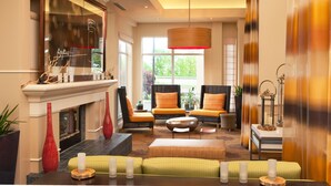 A spacious lobby with a fireplace, seating area, and large windows.