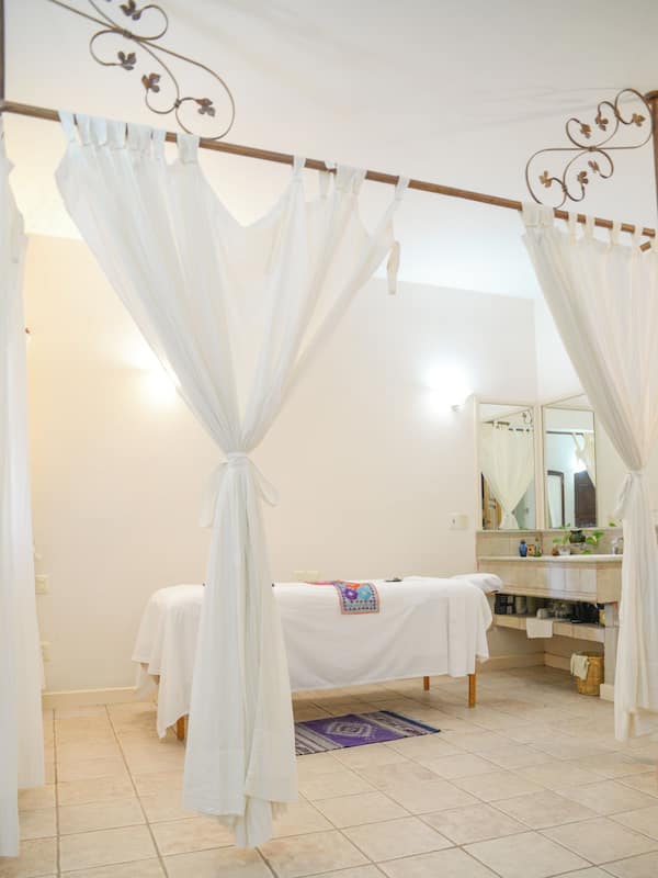 Relax in a serene space with a central bed area, large mirror, and a cozy rug.