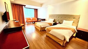 A hotel room with two beds, a desk, a chair, and a TV. - Tai Pan Hotel (Bangkok)