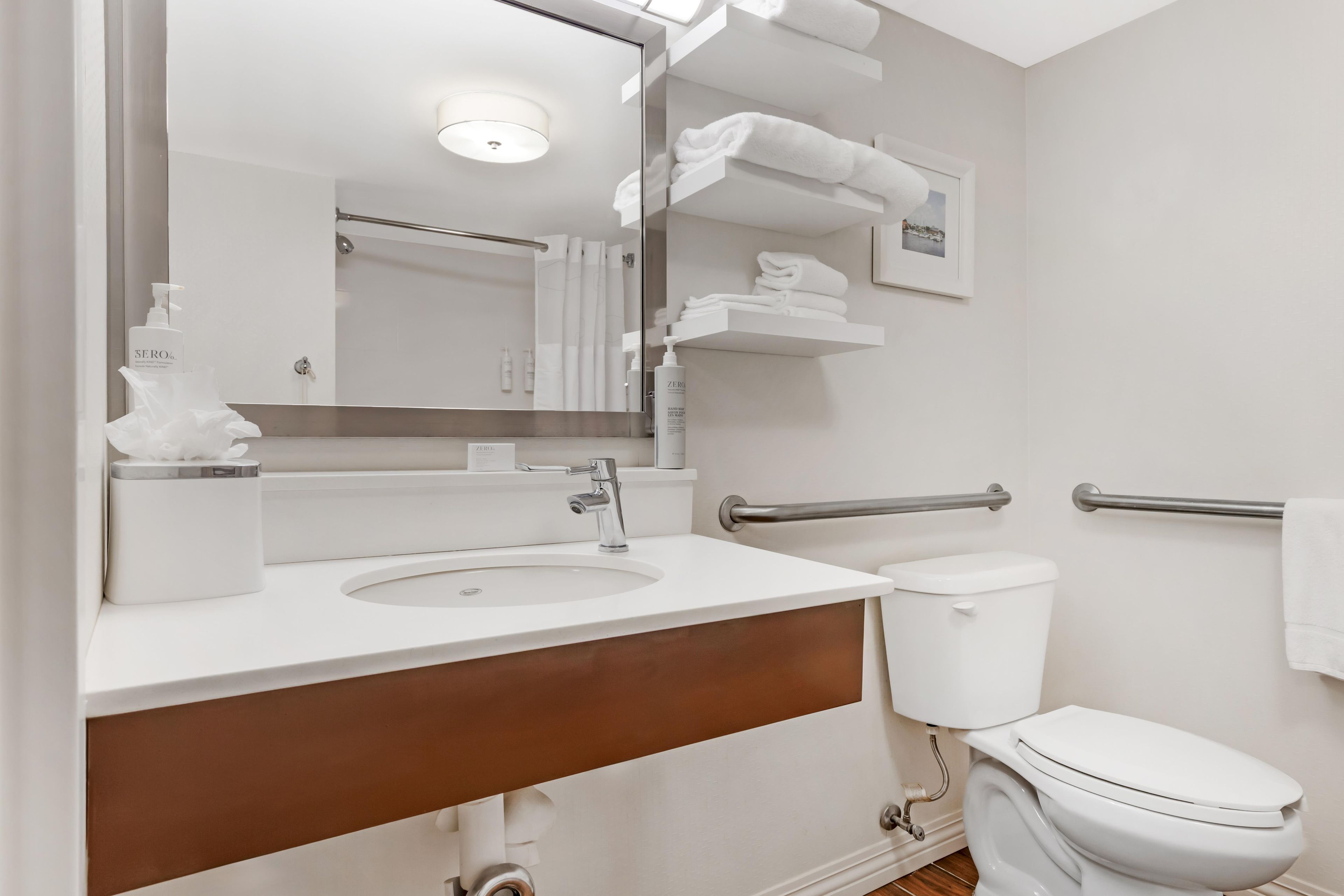A modern bathroom with a sink, toilet, and a mirror.